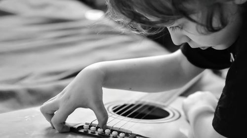 Close-up of boy playing guitar