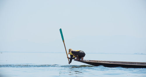 Man on boat over sea against clear sky