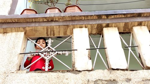 Portrait of man sitting on wall