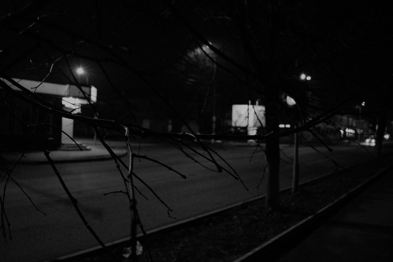 ILLUMINATED STREET AMIDST BUILDINGS AT NIGHT