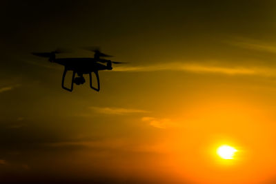 Low angle view of silhouette airplane against sky during sunset