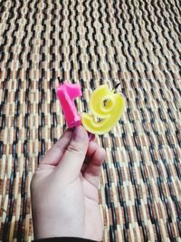 Close-up of hand holding yellow toy