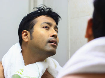 Man looking in mirror at bathroom