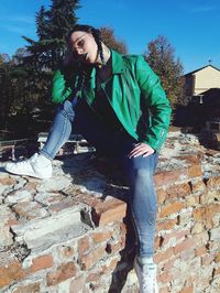 Young woman smiling against wall