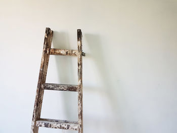 Close-up of wooden ladder against wall