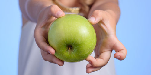 Midsection of woman holding apple