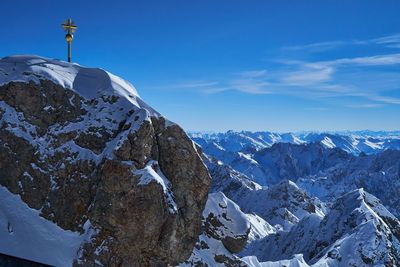 Scenic view of snowcapped mountains against blue sky