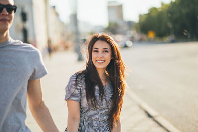 Portrait of happy woman standing in city