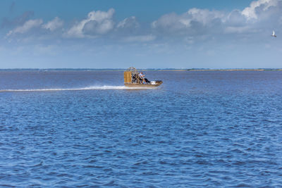 Boat sailing on sea against sky