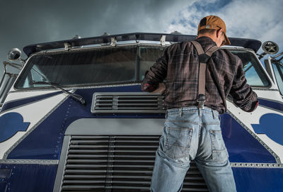 Full length of man standing by car against sky