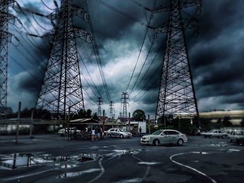 Cars on road against cloudy sky