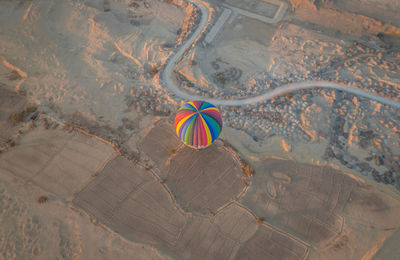 High angle view of hot air balloon flying over land