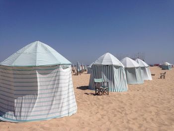 Tents on beach against clear sky