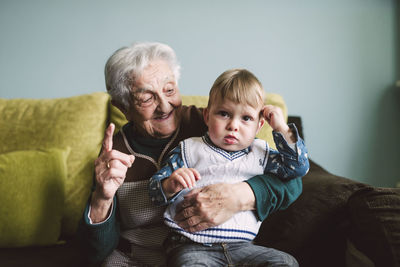 Old woman and her great-grandson sitting on the couch