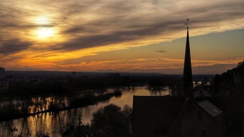 Silhouette buildings against sky during sunset