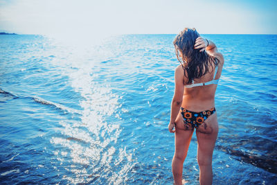 Rear view of woman standing in sea