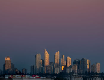 Cityscape of vancouver skyline against dark sky at sunset