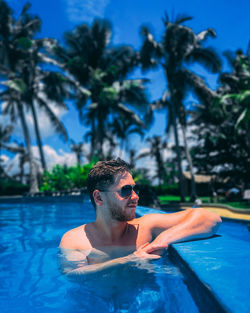 Shirtless man swimming in pool