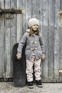 Full length portrait of woman standing in front of closed door