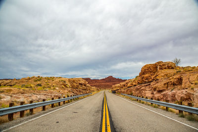 Road passing through mountain against sky