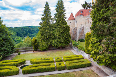 Trees and plants in garden against building