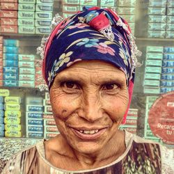 Close-up portrait of smiling woman against wall