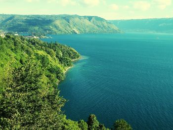 High angle view of sea and mountains against sky