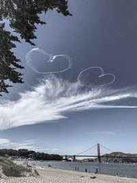 Suspension bridge over sea against sky