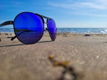 Close-up of sunglasses on beach