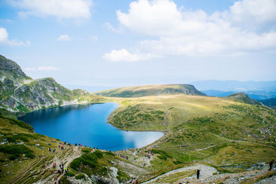 Scenic view of lake and mountains against cloudy sky