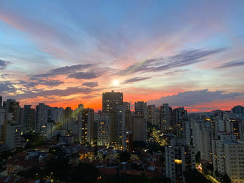 Illuminated buildings against sky during sunset