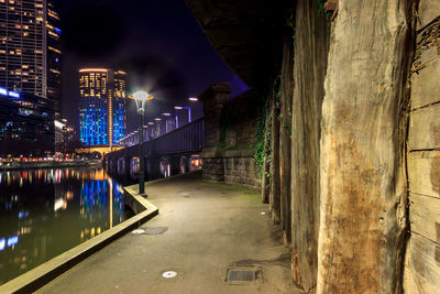 Illuminated road amidst buildings in city at night