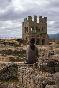 Rear view of woman looking at abandoned built structure