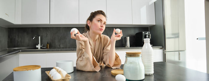 Portrait of young woman sitting in bathroom