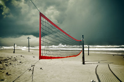 Lifeguard hut on beach against sky during winter