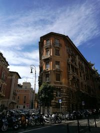 Cars on city street against sky