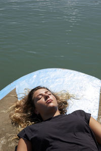 A girl lying with her eyes closed sunbathing