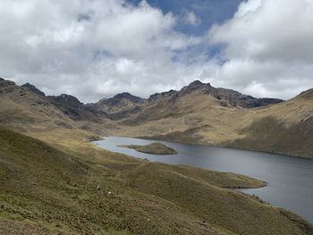 Scenic view of lake by mountains against sky