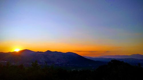 Scenic view of silhouette mountains against sky during sunset