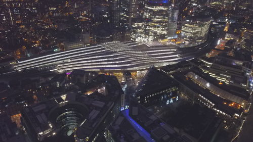 High angle view of illuminated street amidst buildings at night