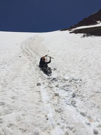 Low angle view of man sliding on snowcapped mountain