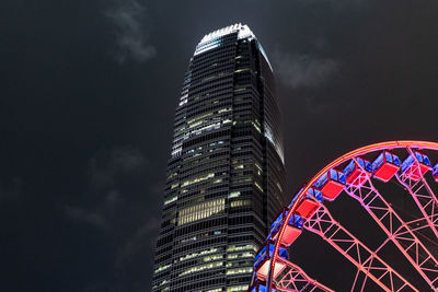 Low angle view of illuminated buildings against sky at night