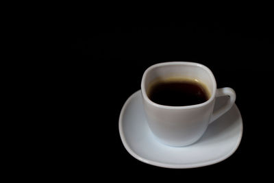 Close-up of coffee cup against black background