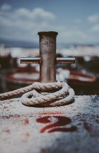 Close-up of rusty metal railing by sea against sky