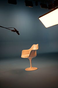 Illuminated electric lamp hanging over chair