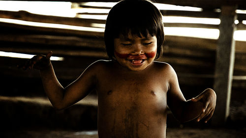 Portrait of shirtless boy standing in bathroom