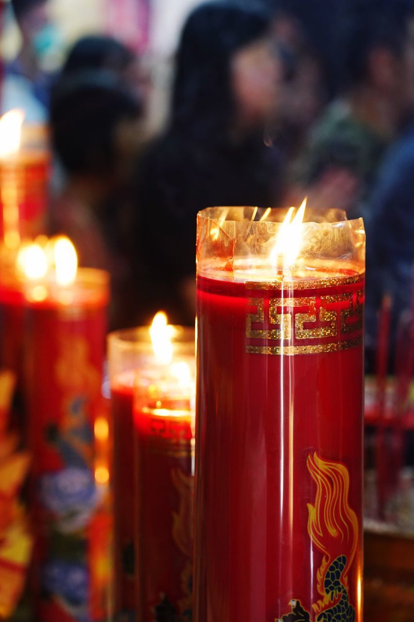 CLOSE-UP OF LIT CANDLES IN GLASS