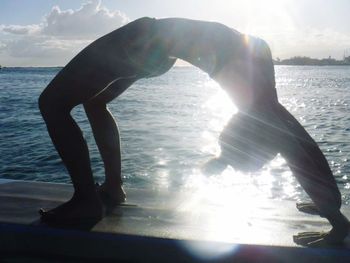 Reflection of man in sea against sky