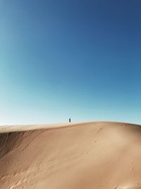 Scenic view of desert against clear blue sky