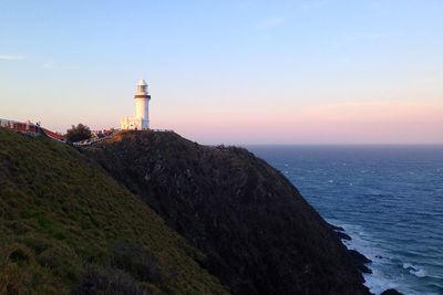 Cape byron light on mountain by sea against sky during sunset